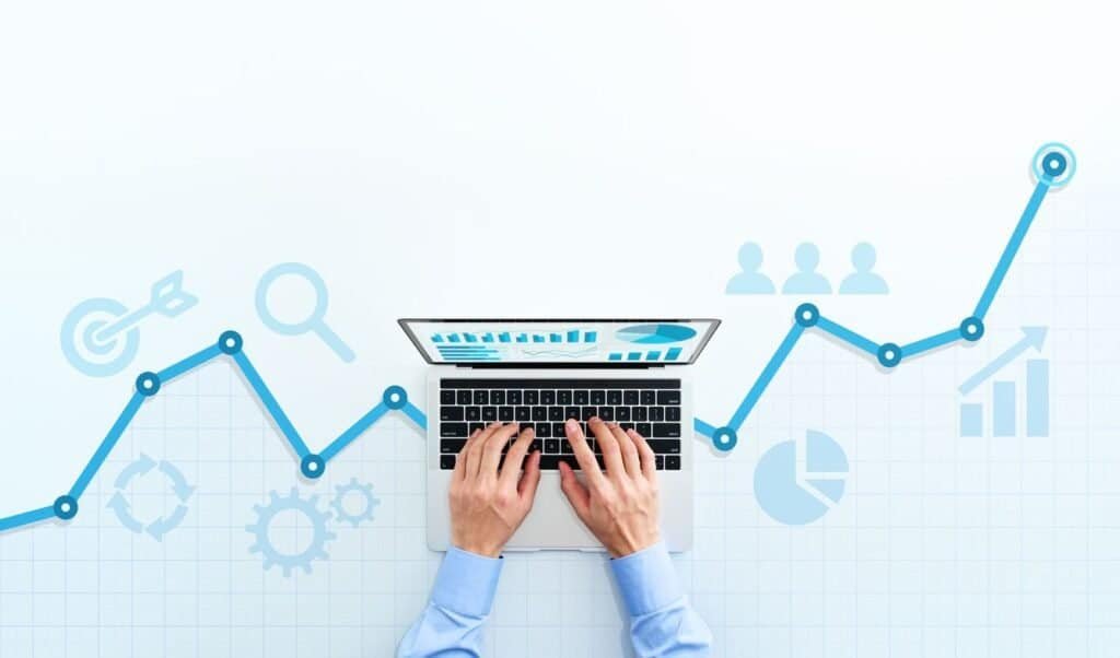 Data Analytics chart on a laptop being using for Business Analytics shown by a man using the laptop from a top view